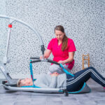 Osoba w sprzęcie rehabilitacyjnym podczas sesji terapeutycznej.