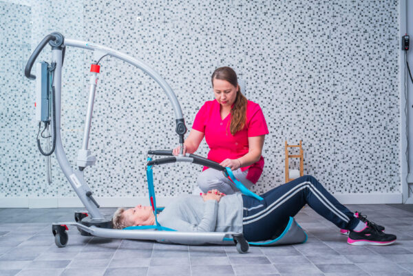Osoba w sprzęcie rehabilitacyjnym podczas sesji terapeutycznej.