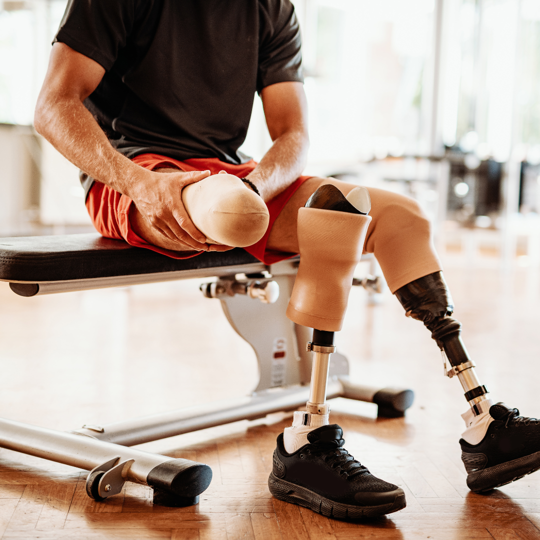 Mężczyzna z protezami nóg przygotowuje się do treningu w siłowni.